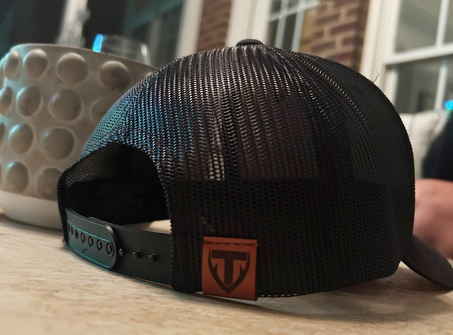 Black mesh cap with Teton Vortex logo on a wooden surface