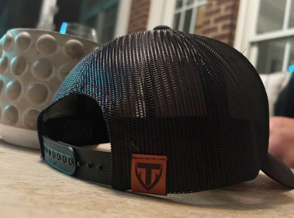 Black mesh cap with Teton Vortex logo on a wooden surface
